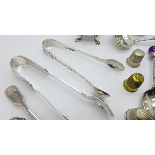 874 - A collection of silver, two pairs of sugar bows, pill box, mustard spoon, tooth pick, 137g and a col... 