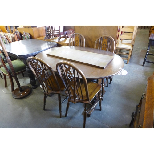 303 - An Old Charm oak extending dining table and four chairs