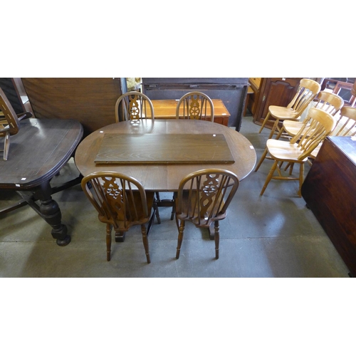 303 - An Old Charm oak extending dining table and four chairs