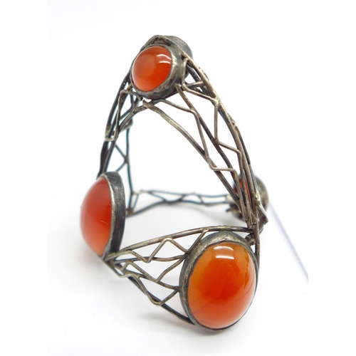 934 - A silver and abalone cabochon ring, a silver and cornelian ring, an enamel and orange stone brooch, ... 