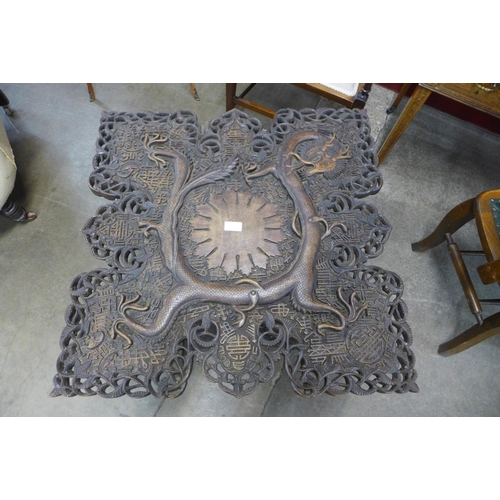 99 - An oriental carved softwood occasional table