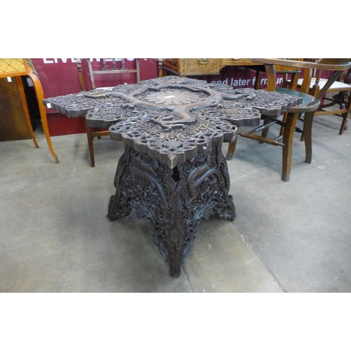 99 - An oriental carved softwood occasional table