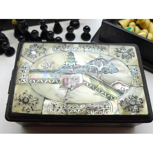 653 - Two small mother of pearl inlaid boxes with assorted chess pieces, a/f, largest box 24cm wide