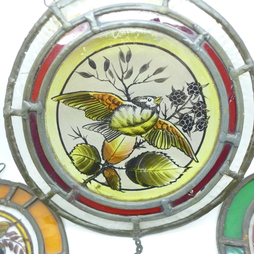 773 - Four circular leaded and coloured glass windows depicting birds, two 21.5cm, two 17.5cm