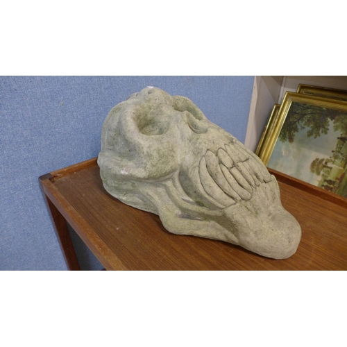 381 - A concrete primate skull garden ornament