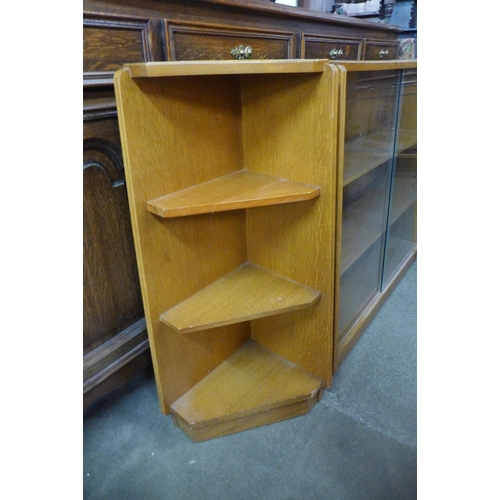 174 - A light oak bookcase and pair of matching corner cabinets