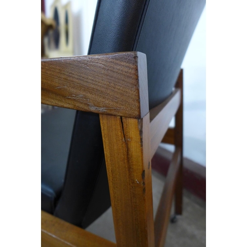 220 - A teak and black vinyl elbow chair