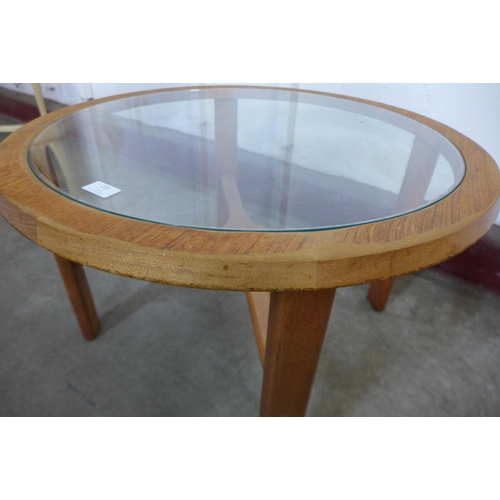 222 - A teak and glass topped circular coffee table