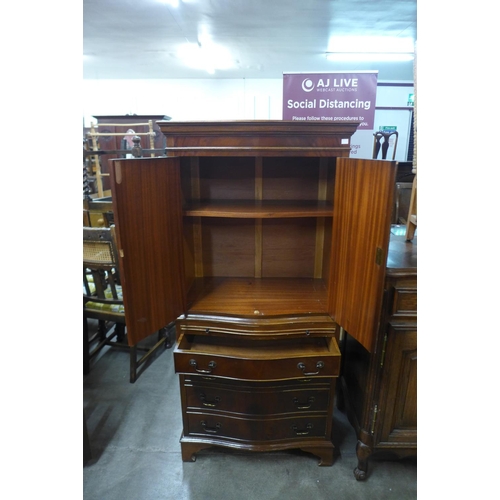 275h - A mahogany serpentine cabinet on chest