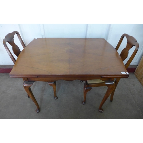 296g - A walnut draw-leaf dining table and four chairs