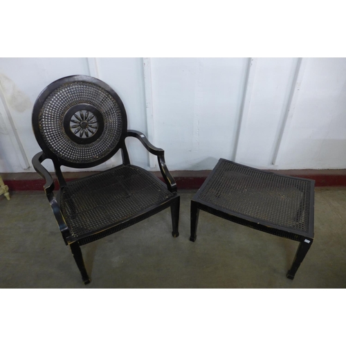 304 - A French style ebonised bergere library chair and matching stool