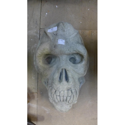 381 - A concrete primate skull garden ornament