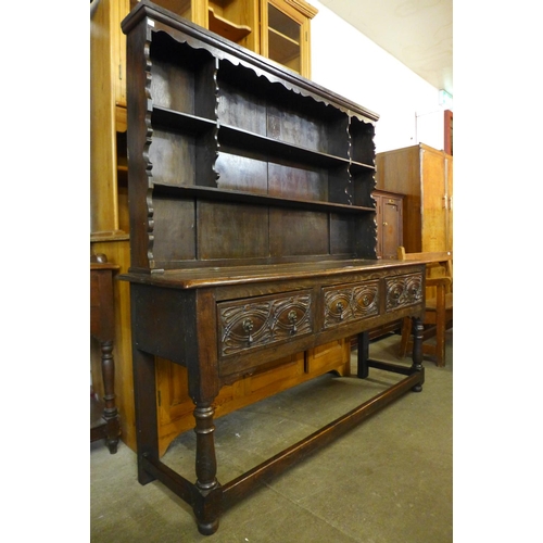 74 - A 17th Century carved oak dresser base, with later Delft rack, 170cms h, 167cms w, 48cms d