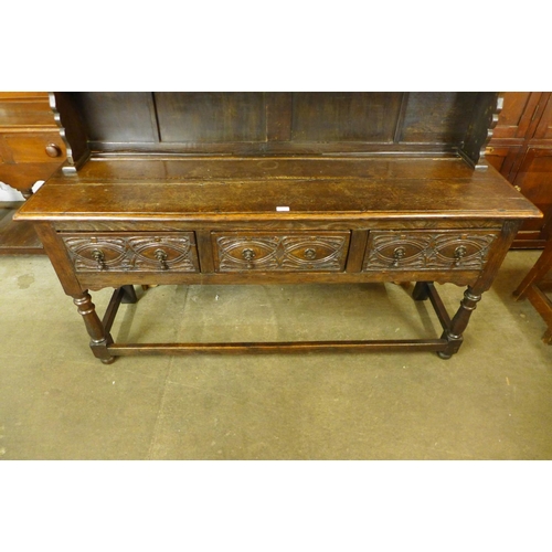 74 - A 17th Century carved oak dresser base, with later Delft rack, 170cms h, 167cms w, 48cms d