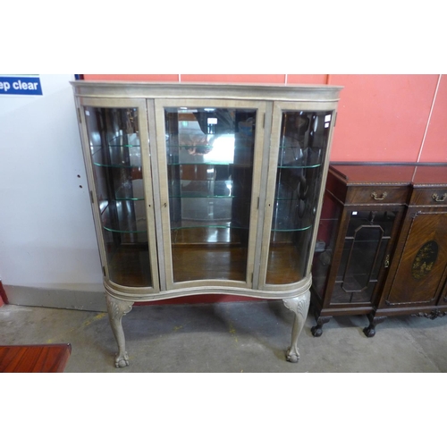 85 - A Queen Anne style bleached walnut serpentine front display cabinet, 152cms h, 130cms w, 50cms d