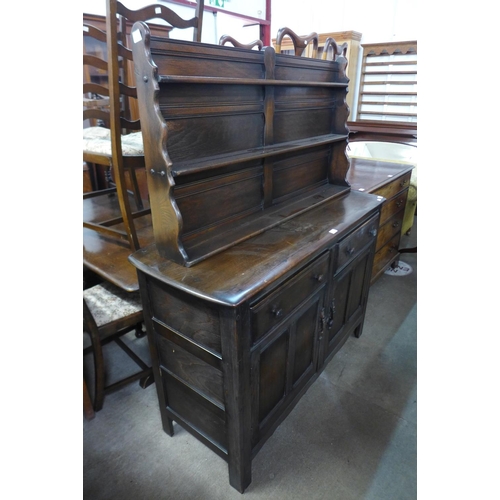 325 - An Ercol Old Colonial dark elm dresser, refectory table and six ladderback chairs