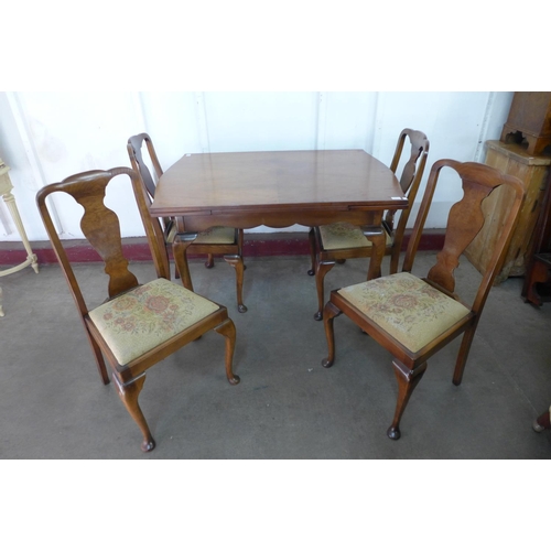 326 - A walnut draw-leaf dining table and four chairs