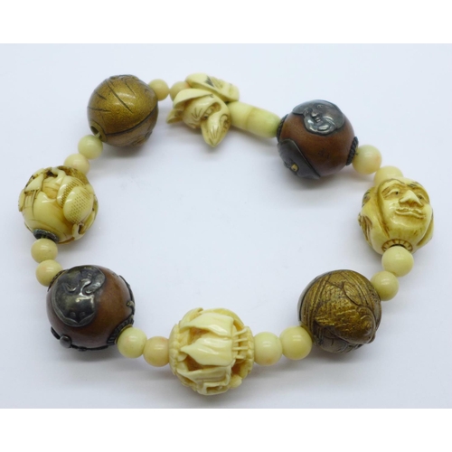 1006 - An oriental bracelet including carved ivory and metal mounted beads