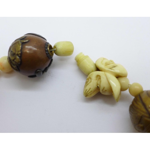 1006 - An oriental bracelet including carved ivory and metal mounted beads