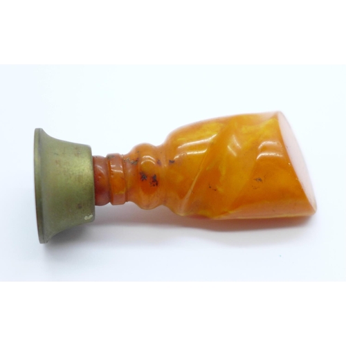 1021 - A seal with a carved amber handle, 66mm