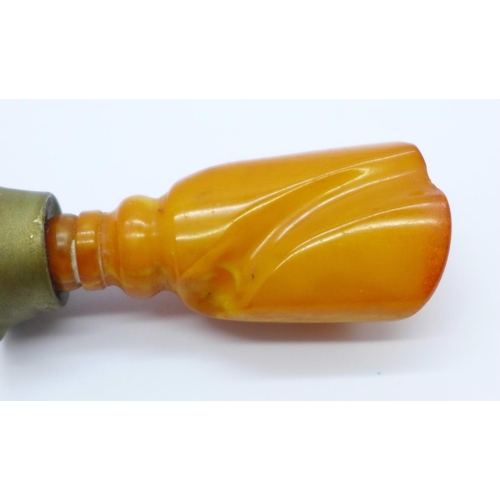 1021 - A seal with a carved amber handle, 66mm