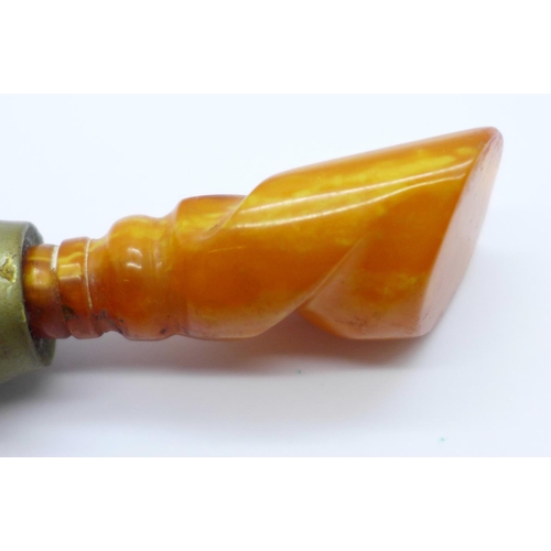 1021 - A seal with a carved amber handle, 66mm