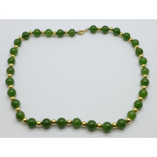 1026 - A jade and yellow metal necklace, the fastener marked 585, 41cm