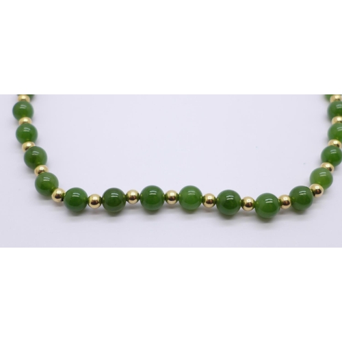 1026 - A jade and yellow metal necklace, the fastener marked 585, 41cm