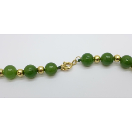 1026 - A jade and yellow metal necklace, the fastener marked 585, 41cm