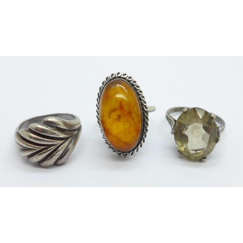 1034 - A Russian silver and amber ring, size N, and two other silver rings, (size M, shank a/f and stone se... 