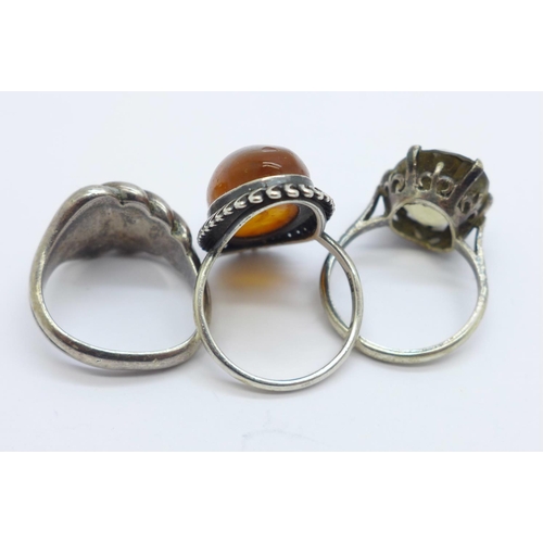 1034 - A Russian silver and amber ring, size N, and two other silver rings, (size M, shank a/f and stone se... 