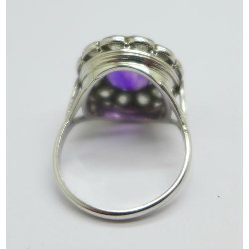 1042 - A platinum, amethyst and diamond cluster ring, marked 'plat', 5.8g, M, ring top 15mm