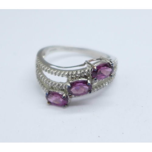 1054 - A 9ct gold, magenta garnet and white sapphire ring, 3.4g, S