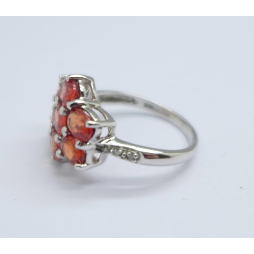 1056 - A 9ct white gold, hessonite garnet cluster ring, with diamond shoulders, 3g, K