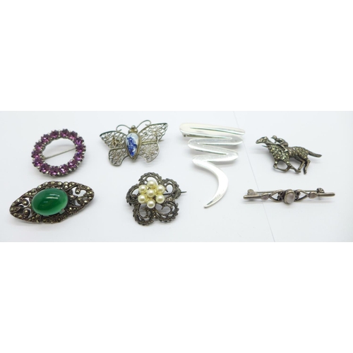 1137 - Six silver brooches including a silver and marcasite horse and jockey brooch, and one other brooch s... 