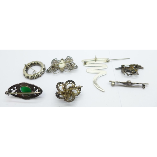 1137 - Six silver brooches including a silver and marcasite horse and jockey brooch, and one other brooch s... 