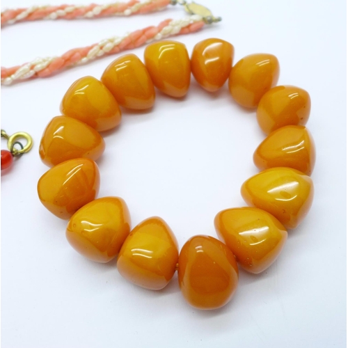 1148 - A coral and pearl necklace, one other necklace and an amber coloured bracelet