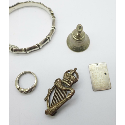 1152 - Two silver bangles, an Irish regimental badge, a silver date pendant, three silver rings, two other ... 