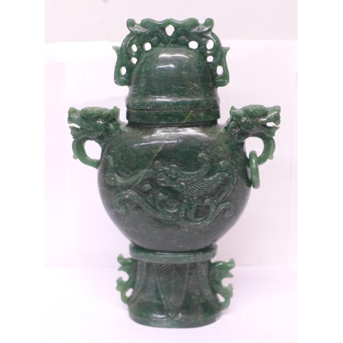 629 - A carved green stone urn with lid, small losses to the lid and one ring missing, 23cm