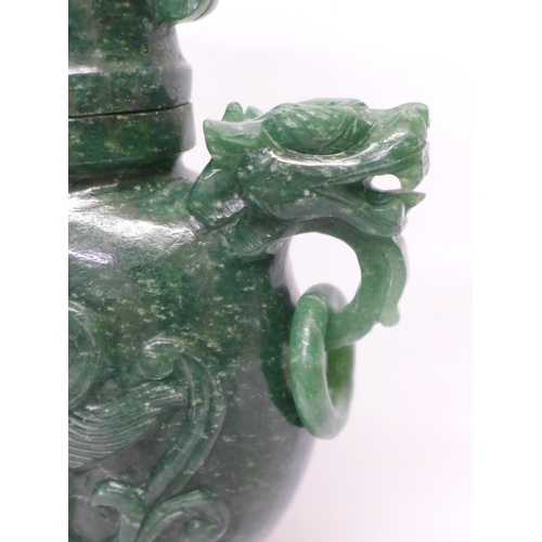 629 - A carved green stone urn with lid, small losses to the lid and one ring missing, 23cm