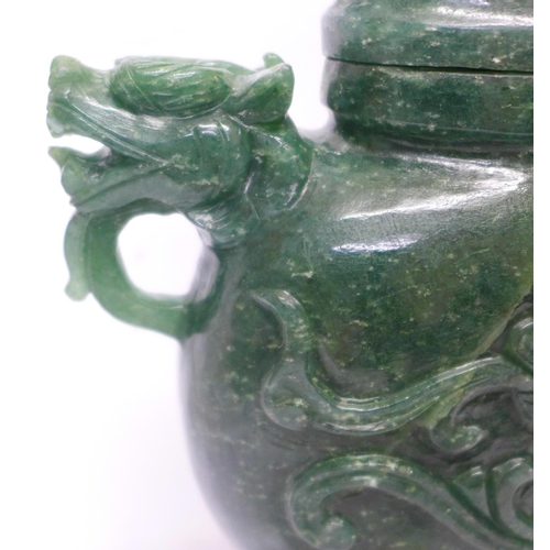 629 - A carved green stone urn with lid, small losses to the lid and one ring missing, 23cm