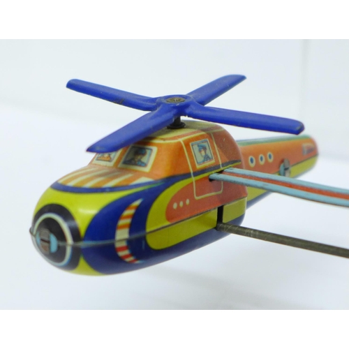 646 - A tin-plate clockwork helicopter toy, made in Western Germany, and one other tin-plate clockwork toy... 