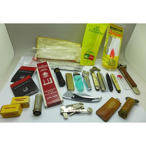 654 - A cigar cutter marked Solingen, pipe knives and cleaners, lighters, Dunhill lighter flints, etc.