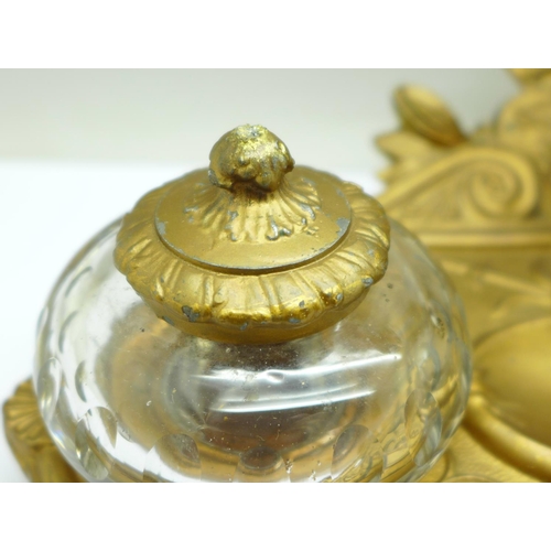 658 - A c.1900 metal inkstand with two glass inkwells, one top a/f, mounted with a bust marked Cornelle