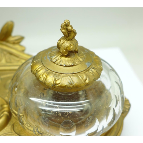 658 - A c.1900 metal inkstand with two glass inkwells, one top a/f, mounted with a bust marked Cornelle