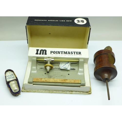 678 - A silver thimble in fitted case, a needle sharpener and a wooden cotton reel holder clamp