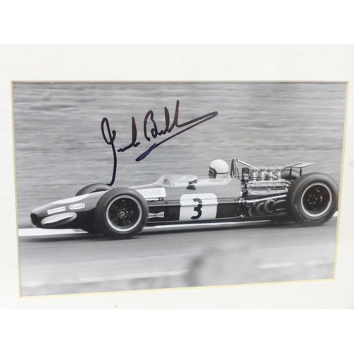 714 - Two signed photographs in one frame; Sir Stirling Moss and Jack Brabham