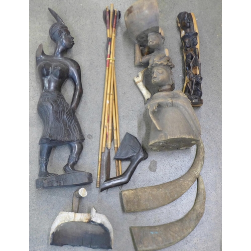 779 - Two carved African figures, a/f, one other carving, two water buffalo horn tips and six bamboo arrow... 