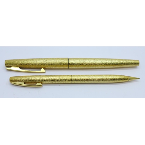 828 - A gold plated Sheaffer fountain pen with 14ct gold nib and a matching propelling pencil