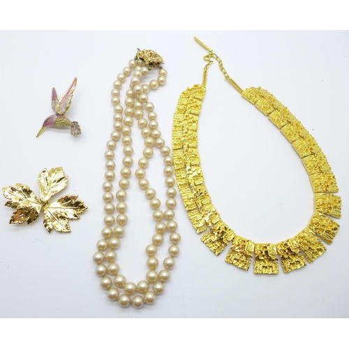 862 - A gilt metal collarette, a double strand faux pearl necklace, a bird brooch and a leaf brooch